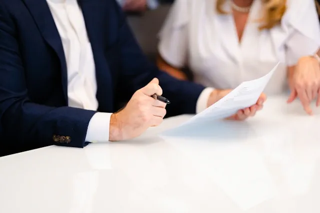 Beschäftigung - Ein Mann und eine Frau arbeiten an einem Vertrag