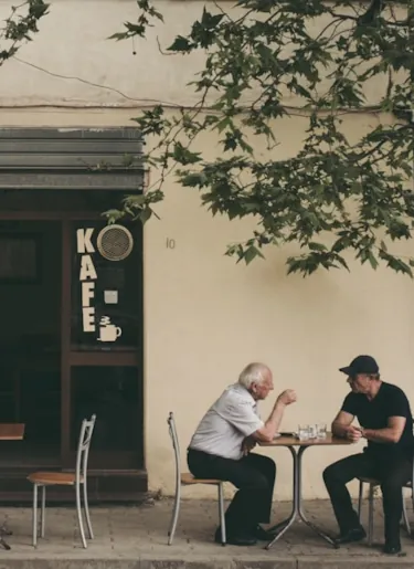 Zwei Einheimische unterhalten sich auf der Terrasse eines Cafés