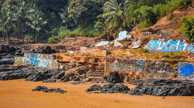 Ein exotischer Strand, der von Graffiti auf den Felsen verwüstet wurde